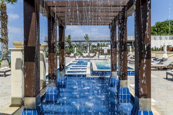 Außenpool im Alexander The Great Hotel mit blauer Wasserfläche und Wasserfontänen