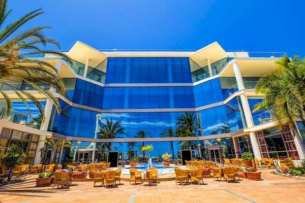 Außenansicht des SBH Hotel Costa Calma Palace mit Glasfassade und Terrasse mit Tischen und Stühlen