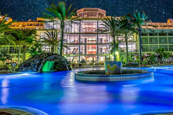 Nachtansicht des SBH Hotel Costa Calma Palace mit beleuchtetem Pool und Palmen