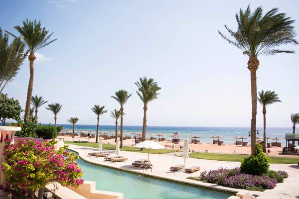 Hotelpool mit Palmen am Meer