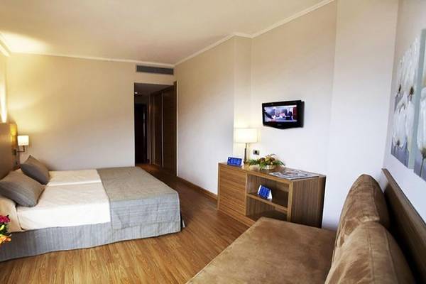 Doppelbettzimmer im Be Live Adults Only Tenerife Hotel mit Fernseher, Nachttisch und Blumen
