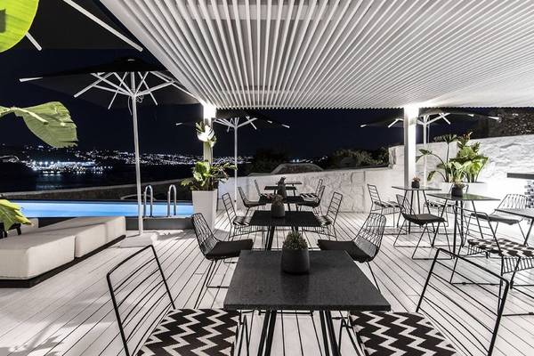 Luxus-Terrasse mit Pool, Tischen, Stühlen und Stadtblick bei Nacht