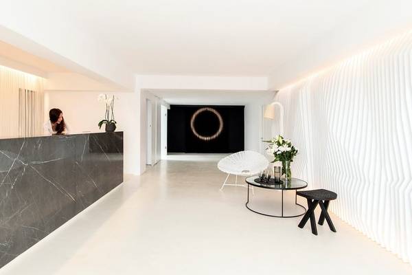 Lobby des Nimbus Hotel mit Marmortresen, modernem Stuhl und dekorativem Kunstwerk