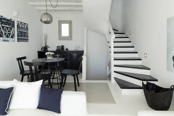 Moderner Wohnbereich im Nimbus Hotel mit Couch, Tisch und Treppe