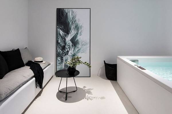 Moderner Wohnbereich im Nimbus Hotel mit Palmenbild, Couch und Badewanne