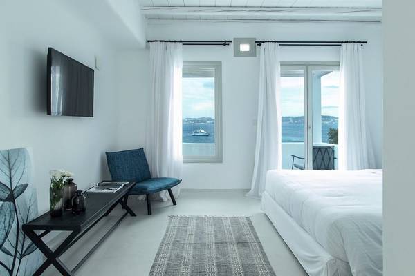 Zimmer im Nimbus Hotel mit Meerblick, Bett, Tisch und Stuhl