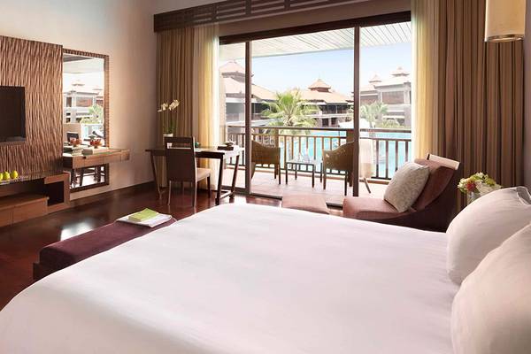 Zimmer im Anantara The Palm Dubai Resort mit Fernseher, Schreibtisch, Balkon und Meerblick.
