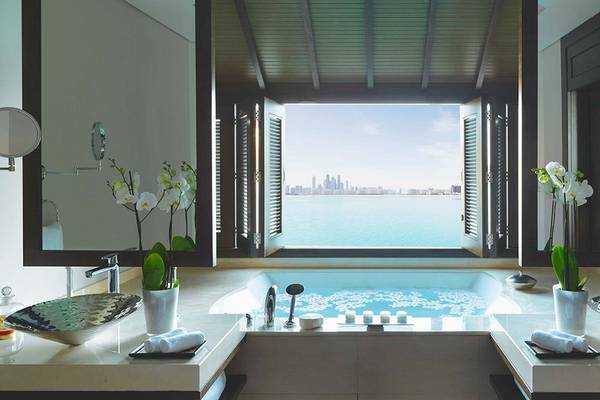 Badezimmer im Anantara The Palm Dubai Resort mit Blick auf das Meer und die Stadt