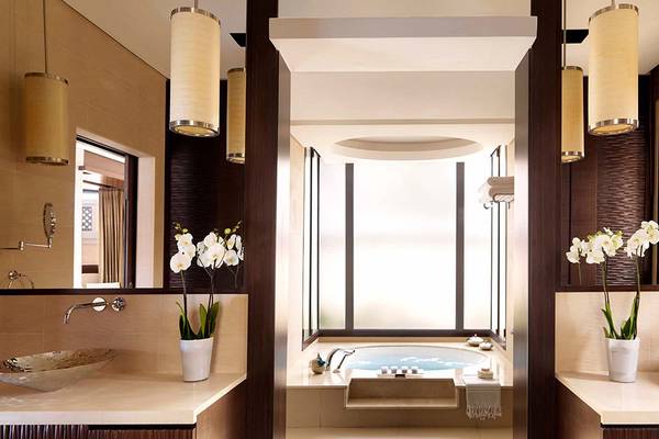 Luxuriöses Badezimmer im Anantara The Palm Dubai Resort mit einem Jacuzzi und zwei Waschbecken.