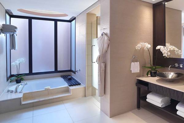 Badezimmer im Anantara The Palm Dubai Resort mit Badewanne, Waschbecken und Spiegel.