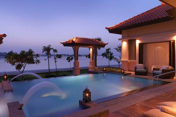 Abendansicht einer Villa mit Swimmingpool und Meerblick im Anantara The Palm Dubai Resort