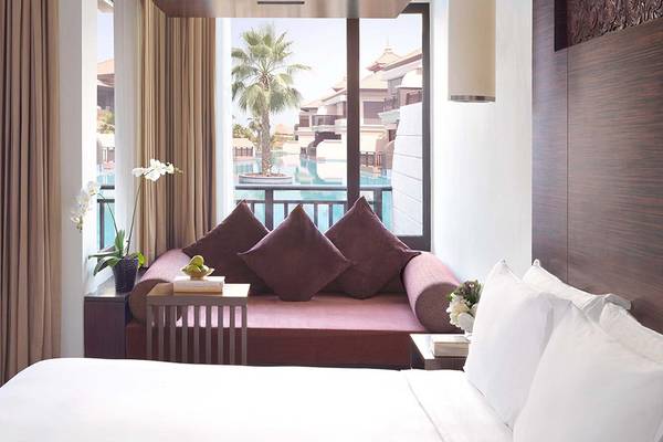 Hotelzimmer im Anantara The Palm Dubai Resort mit Blick auf den Pool.