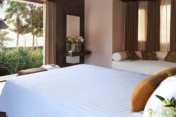 Schlafzimmer im Anantara The Palm Dubai Resort mit großem Bett und großer Fensterfront.