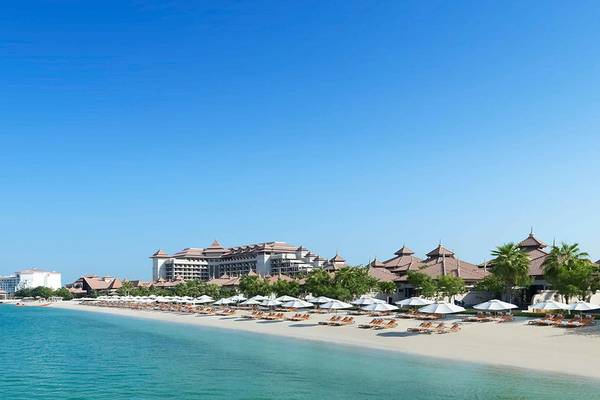 Strand des Anantara The Palm Dubai Resort mit Sonnenschirmen und Liegestühlen