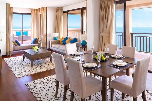 Wohnzimmer im Anantara The Palm Dubai Resort mit Blick auf das Meer und eine Insel.