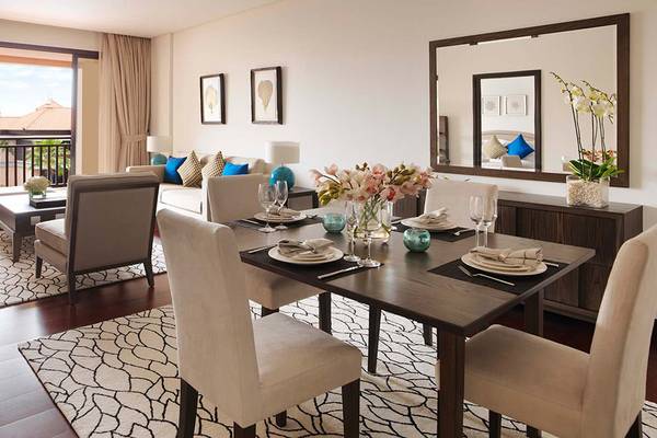 Wohnzimmer des Anantara The Palm Dubai Resorts mit Tisch, Sesseln und Sofa.
