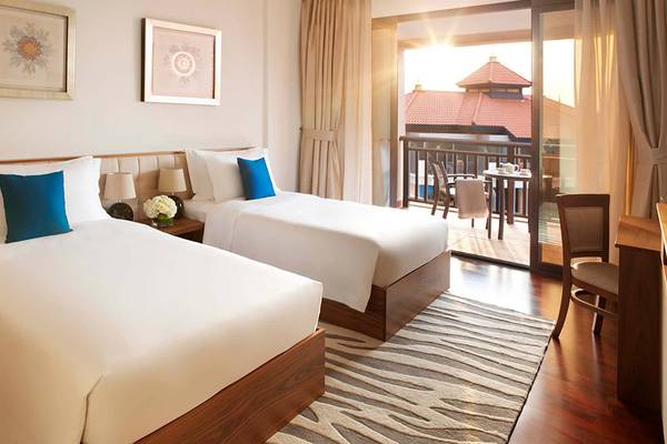 Doppelzimmer im Anantara The Palm Dubai Resort mit zwei Betten und einem Balkon.