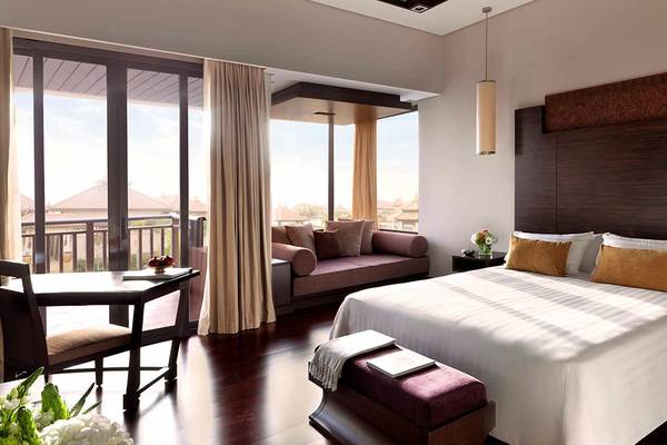 Schlafzimmer im Anantara The Palm Dubai Resort mit großem Bett, Kissen, Couch und Balkon
