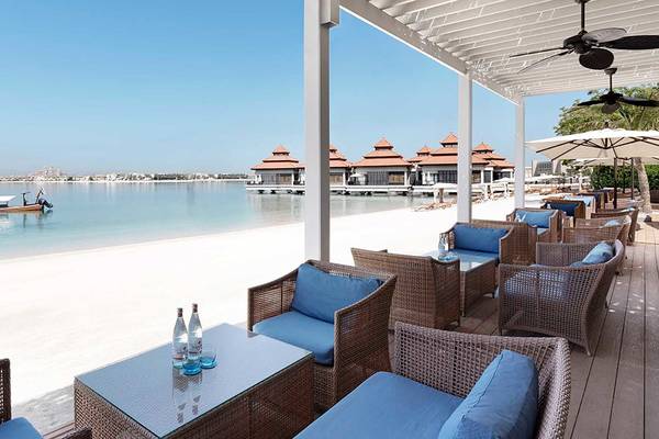 Strandansicht des Anantara The Palm Dubai Resorts mit Blick auf Wasser und Boot