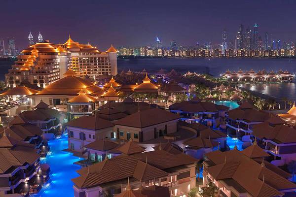 Luftaufnahme des Anantara The Palm Dubai Resorts mit beleuchteten Gebäuden und Pool bei Nacht