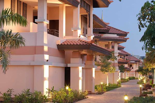 Abendansicht der Anantara The Palm Dubai Resort Villas mit illuminierten Wegen und gut beleuchteten Gebäuden.