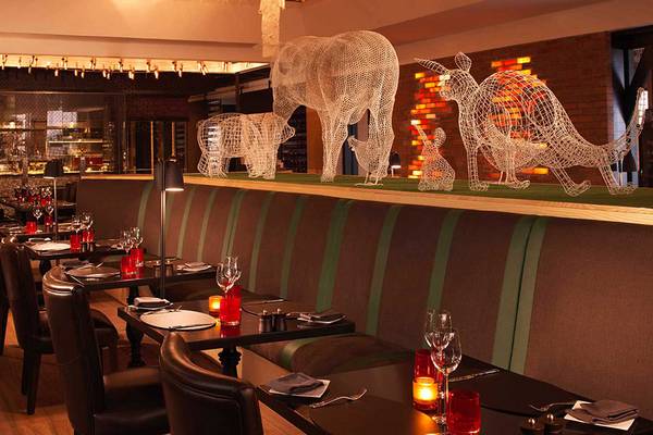 Innenansicht des Restaurants im Anantara The Palm Dubai Resort mit Tisch, Stühlen und Tierskulpturen an der Wand.