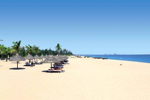 Strand des Boutique Hoi An Resorts mit Liegen und Sonnenschirmen am Meer