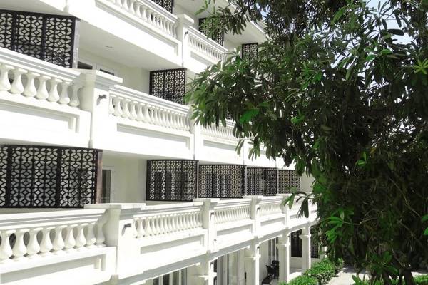Außenansicht des Boutique Hoi An Resorts, einem weißen Gebäude mit Balkonen und schwarzen Gittern