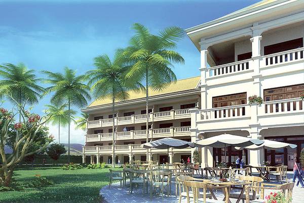 Aussenbereich des Boutique Hoi An Resorts mit Palmen, Tischen und Stühlen unter Schirmen.