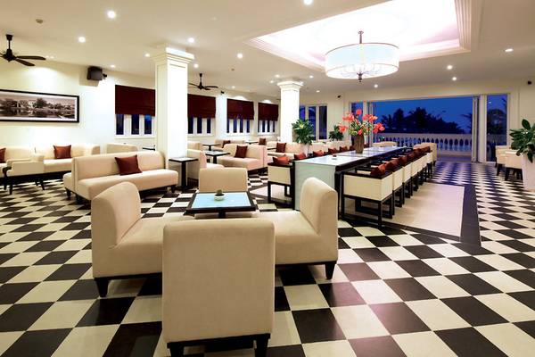 Lobby des Boutique Hoi An Resorts mit schachbrettartigem Boden und modernen Möbeln.