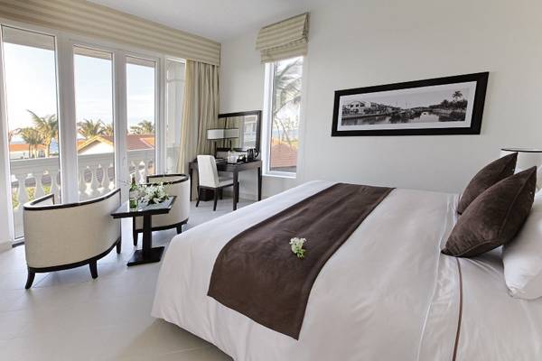 Schlafzimmer im Boutique Hoi An Resort mit Blick auf die Stadt und das Meer.