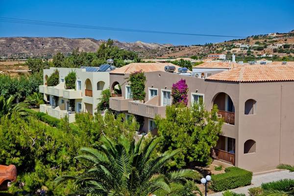 Außenansicht des Akti Beach Club Hotels mit mehreren Gebäuden, Sonnenkollektoren und Pflanzen.