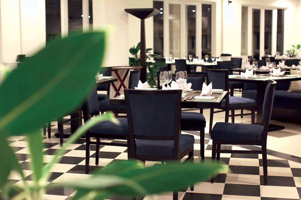 Restaurant-Innenansicht des Boutique Hoi An Resorts mit gedeckten Tischen und Stühlen.