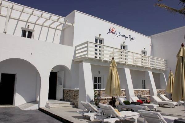 Außenbereich des Beach Boutique Hotels mit weißen Sonnenliegen und Sonnenschirmen.