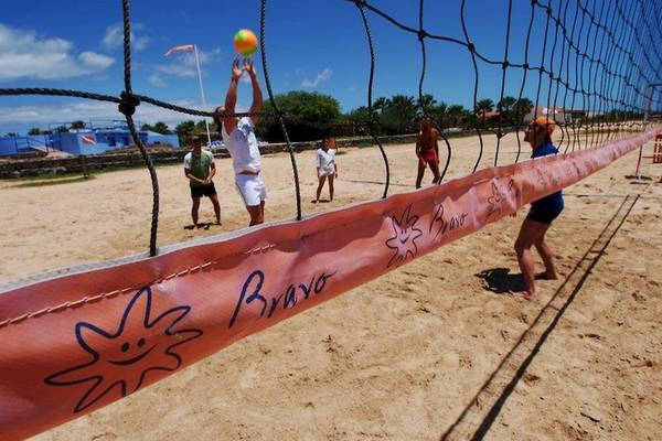 Volleyballspiel am Strand im VOI Vila Do Farol Resort mit mehreren Spielern.