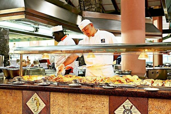 Küche im Buffetrestaurant des VOI Vila Do Farol Resorts mit zwei Köchen, die Speisen zubereiten