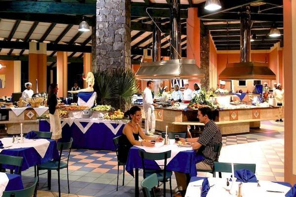 Restaurant im VOI Vila Do Farol Resort mit Gästen an Tischen und gedecktem Buffet.