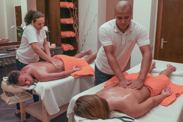 Massage Behandlung im Cleopatra Luxury Beach Resort mit zwei Personen, die Rückenmassagen durchführen.