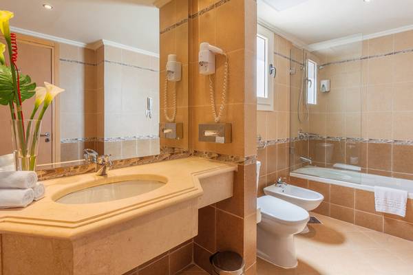 Badezimmer im Cleopatra Luxury Beach Resort mit Waschbecken, Spiegel, Bidet und Badewanne.
