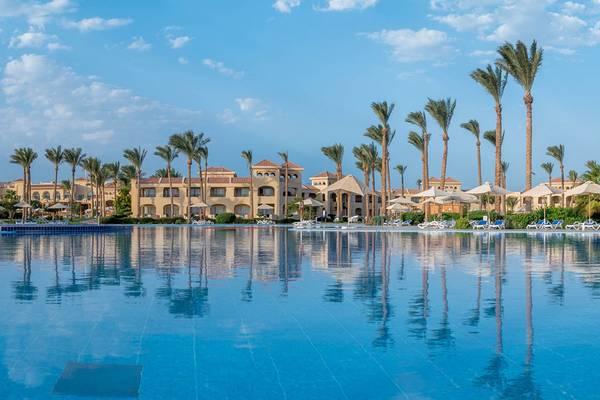 Außenpool des Cleopatra Luxury Beach Resort mit Palmen und Gebäuden im Hintergrund