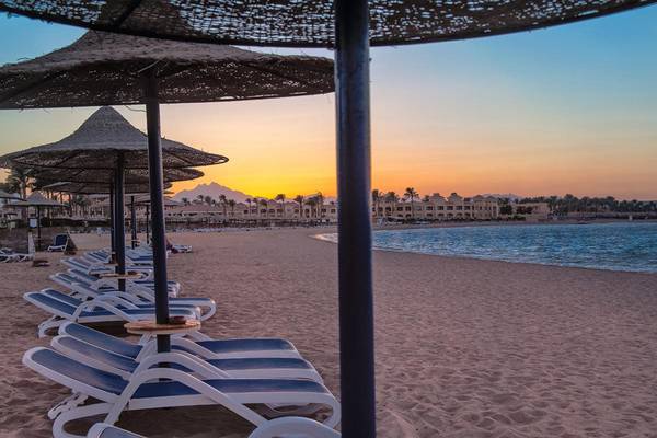 Sonnenuntergang am Strand des Cleopatra Luxury Beach Resorts mit Sonnenschirmen und Liegen