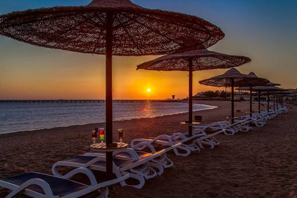 Sonnenuntergang am Strand des Cleopatra Luxury Beach Resorts mit Sonnenschirmen und Sonnenliegen