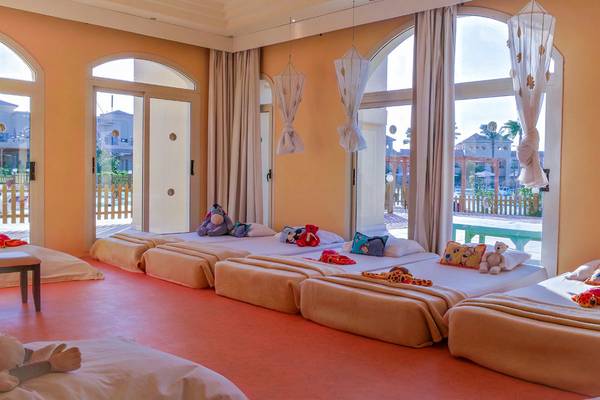 Zimmer im Cleopatra Luxury Beach Resort mit mehreren Betten und Spielzeug.
