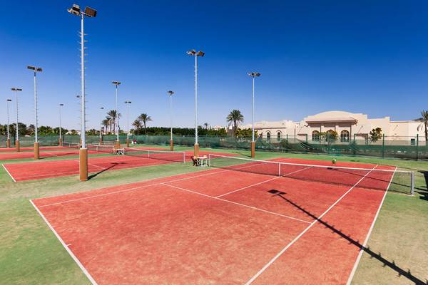 Tennisplatz im Freien mit roten Courts und umliegenden Gebäuden am Cleopatra Luxury Beach Resort