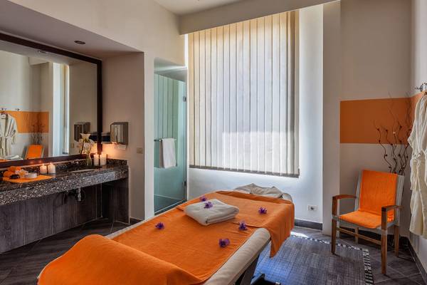 Massagesalon im Cleopatra Luxury Beach Resort mit orangen Handtüchern und einer Dusche.