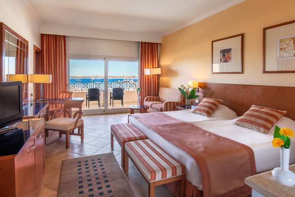 Doppelbett-Zimmer mit Meerblick im Cleopatra Luxury Beach Resort mit Balkon, Fernseher und Wohnzimmermöbeln.