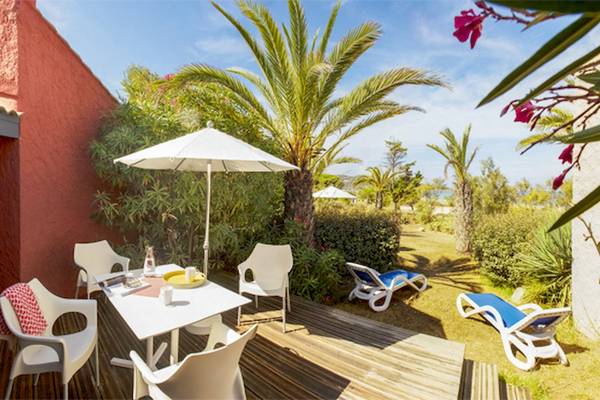 Terrasse im Belambra Club Golfe de Lozari mit Tischen, Stühlen und Sonnenliegen