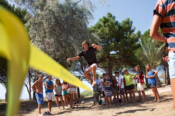 Sportaktivität im Belambra Club Golfe de Lozari mit einem Mann, der springt und eine Gruppe von Zuschauern.
