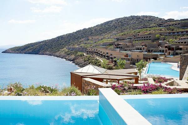 Aussicht auf das Daios Cove Luxury Resort & Villas mit Meer, Klippen und Hotels.