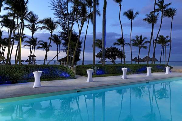 Poolbereich des Melia Caribe Beach Resorts mit Palmen und Meer im Hintergrund
